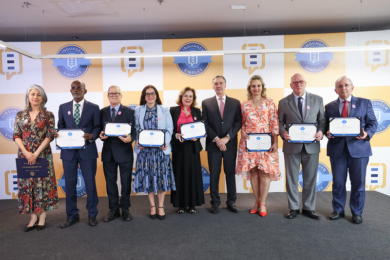 Desembargadoras e desembargadores posando para foto ao lado do ministro Barroso. Eles seguram os certificados recebidos.