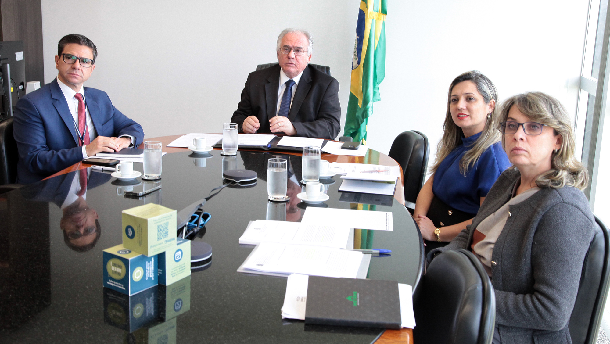 Fotografia da integrantes da Conaproc reunidos em torno da mesa de reunião junto ao ministro Mauricio Godinho Delgado.