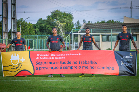 Imagem com jogadores do Sport de Recife com a faixa ''Segurança e Saúde no Trabalho: a prevenção é sempre o melhor caminho''