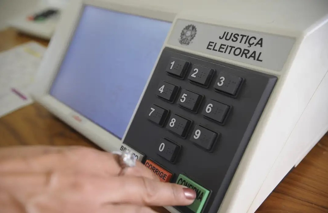 Detalhe de pessoa votando na urna eletrônica